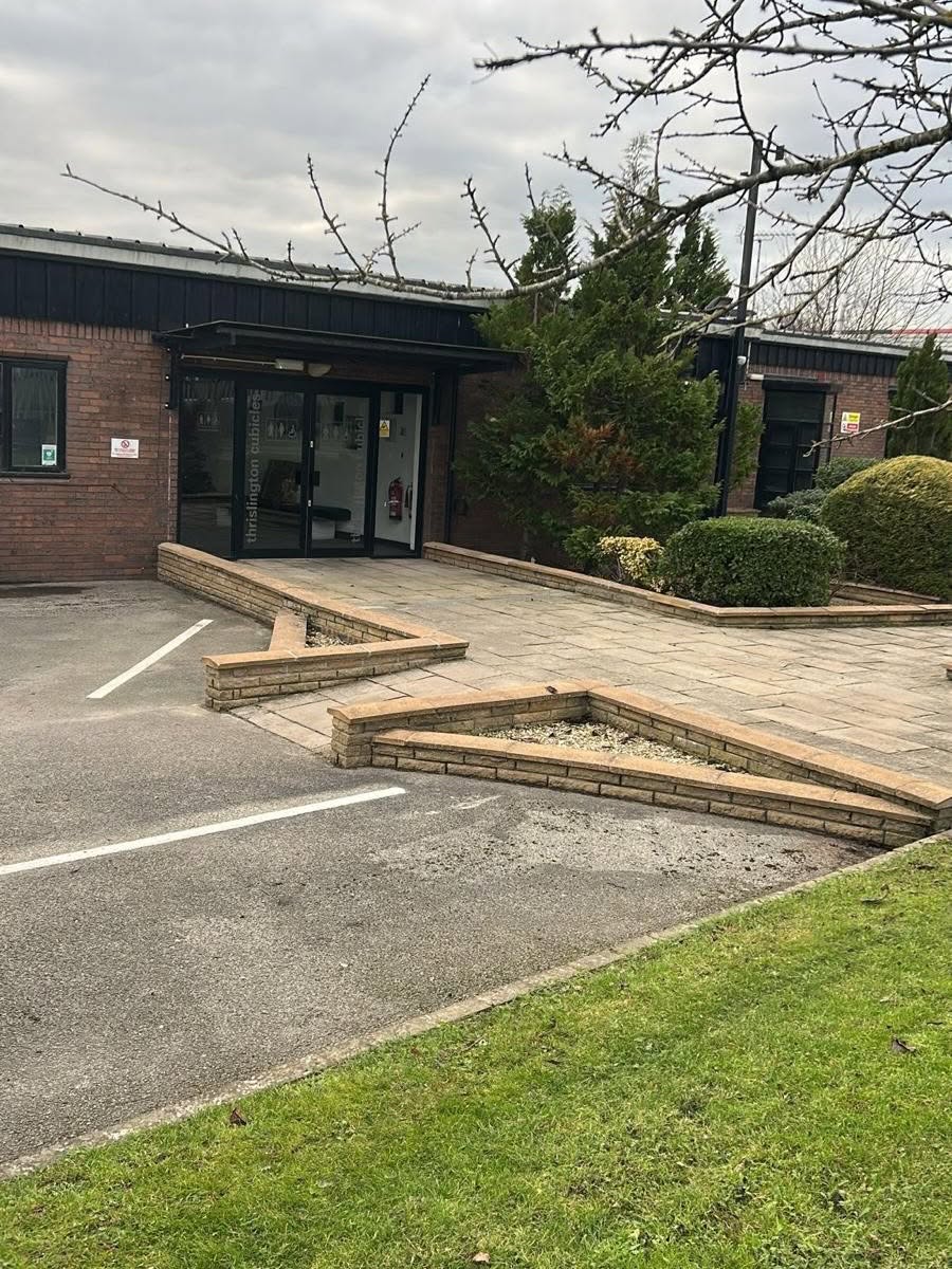 Commercial building entrance with cut lawn and pruned shrubs